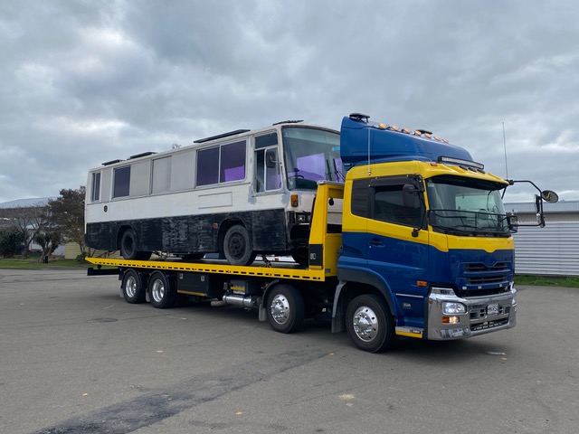 Motorhome bus being transported on a Truck Towing tilt-tray truck